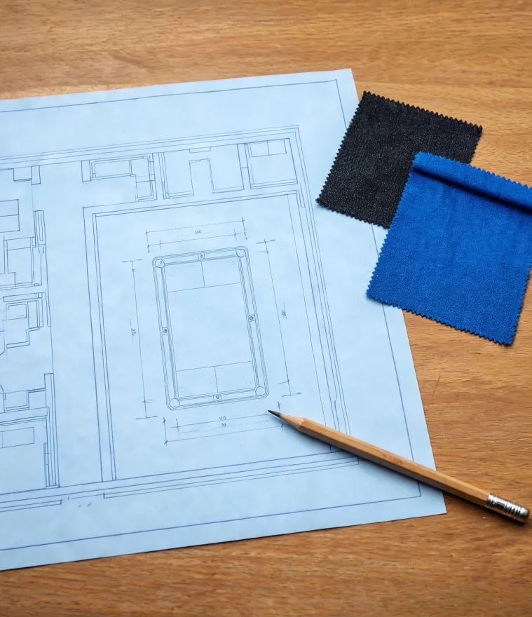 Overhead plan of billiard tables and cloth swatches on a project desk
